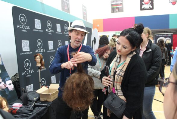 A representative from Denham talks to a hairdressing student