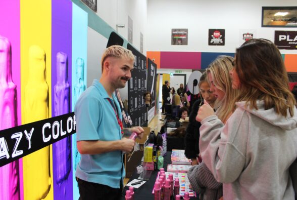 A student chats with Connor Stansfield, an Ambassador from Crazy Color at their stand